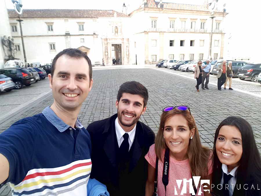 Con dos universitarios con sus capas junto a la entrada de la Universidad de Coímbra